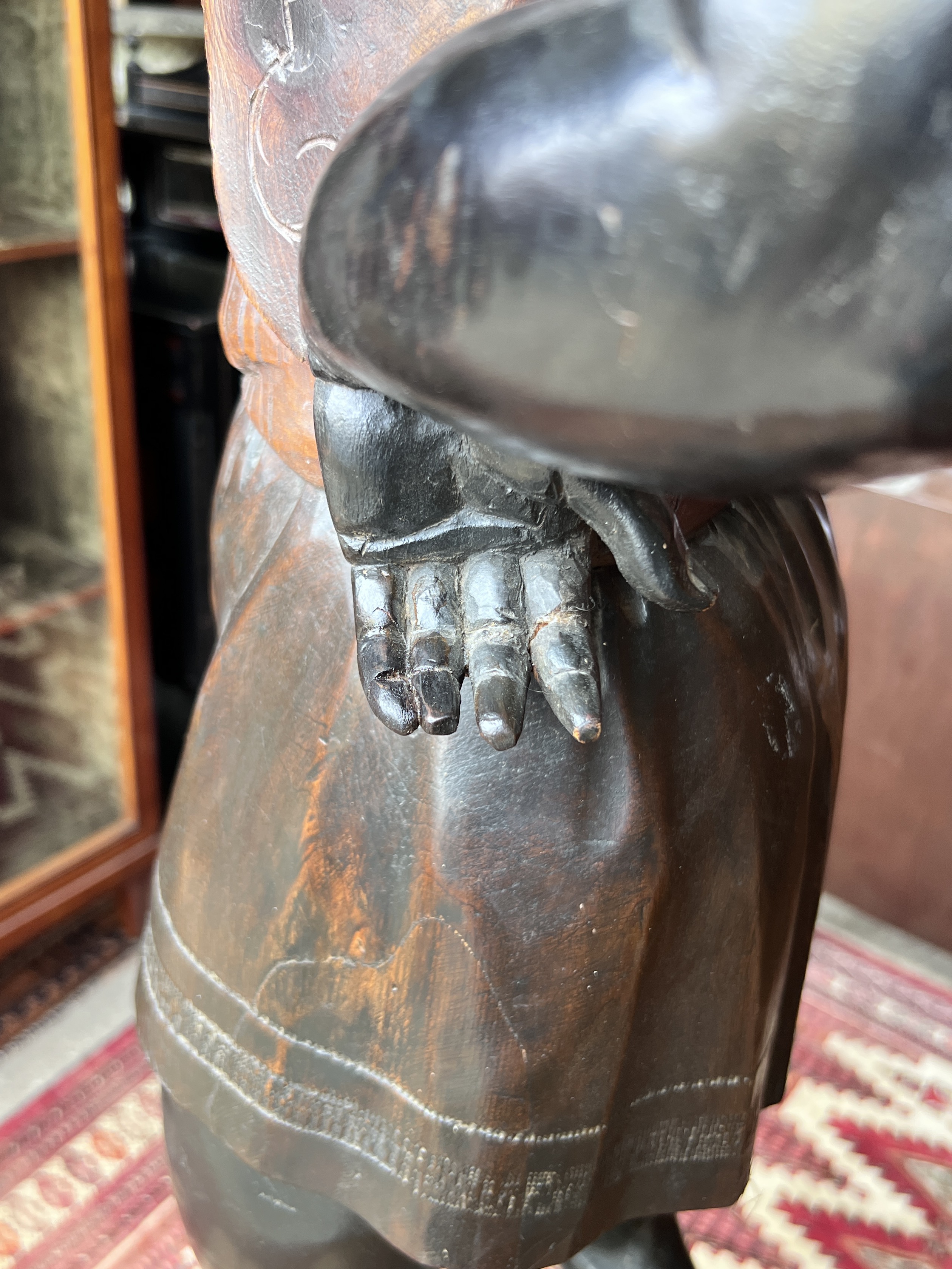 An early 20th century carved wood Blackamoor on associated hexagonal lion mask swagged plinth, height 193cm